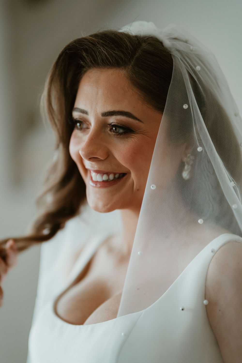 A series of bridal portraits showing a bride in a white veil smiling in soft lighting.