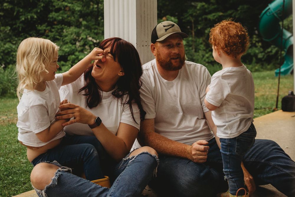 A family enjoying a playful outdoor moment together on stone steps.