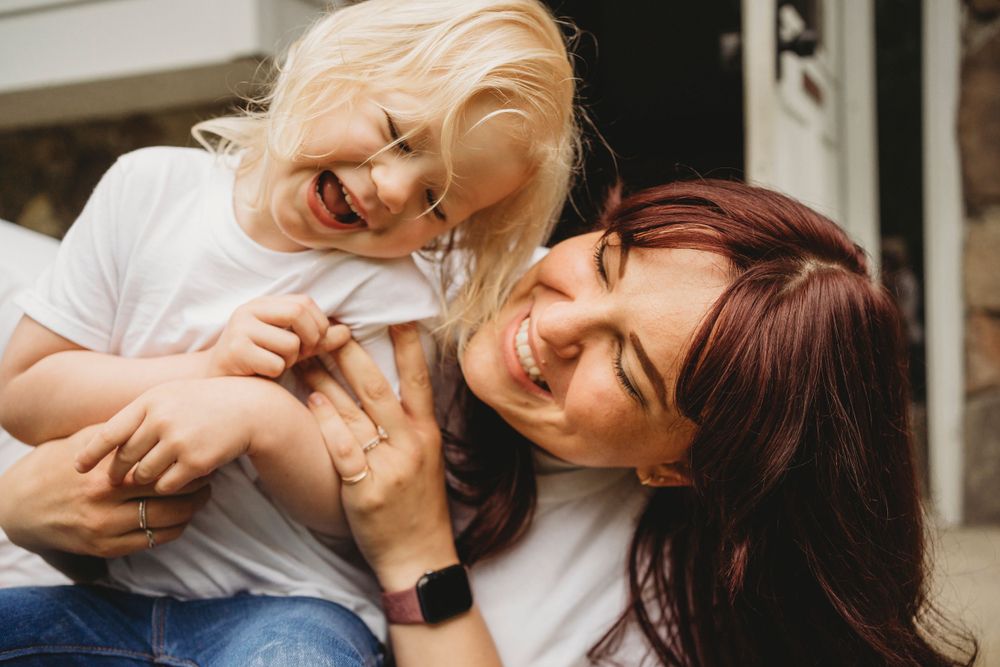 Spontaneous moment of shared laughter and happiness captured on outdoor steps.