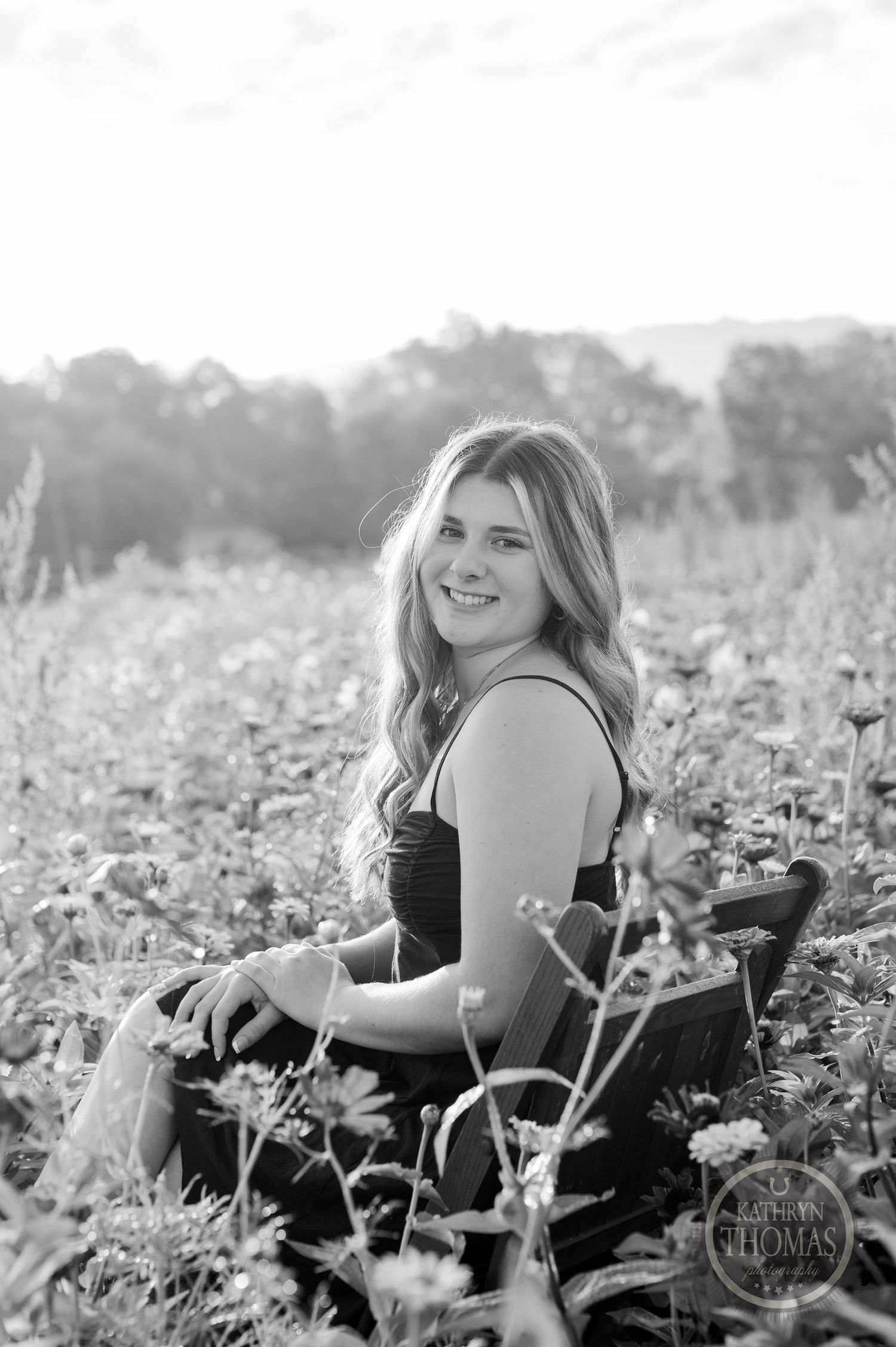 Black and white portrait captured in a scenic wildflower meadow with gentle natural lighting.