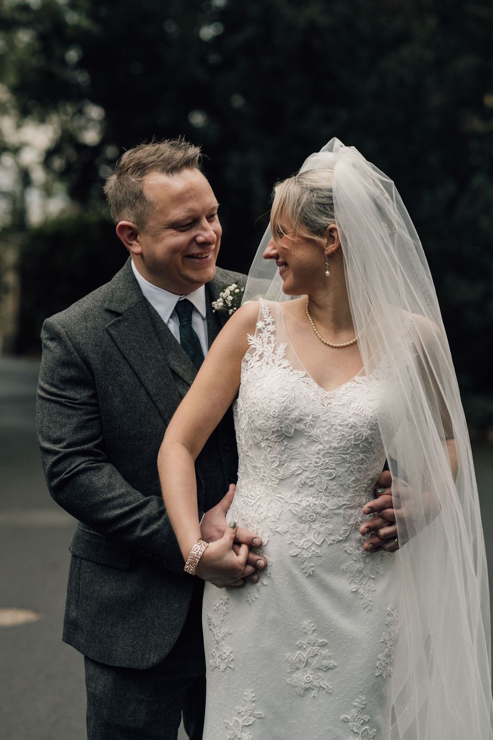 Wedding couple sharing joyful moments together in an outdoor garden setting.