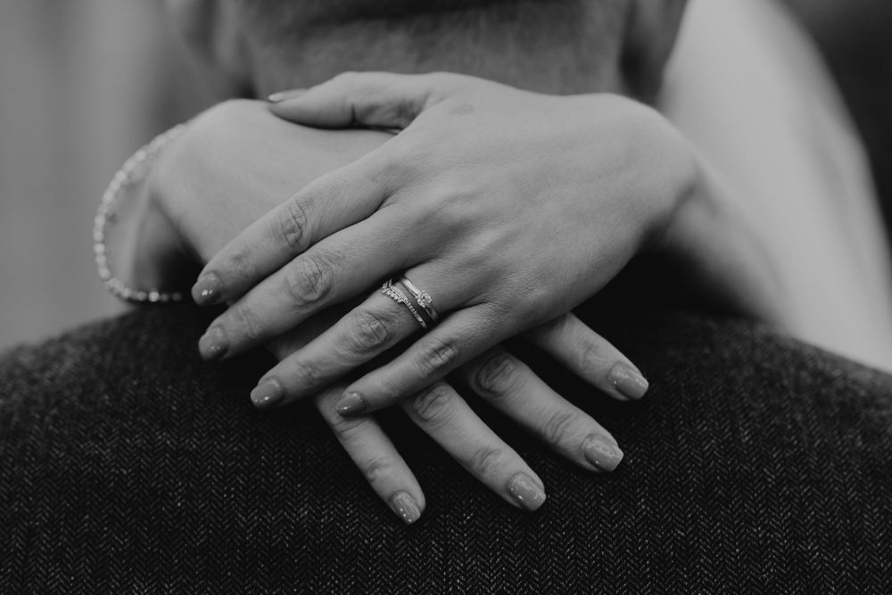 Close-up black and white photo of hands resting gently on fabric.