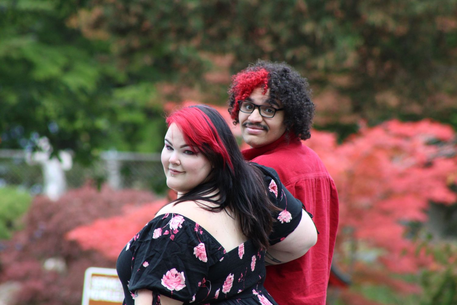 Couple embracing and smiling with colorful foliage, candid outdoor moment