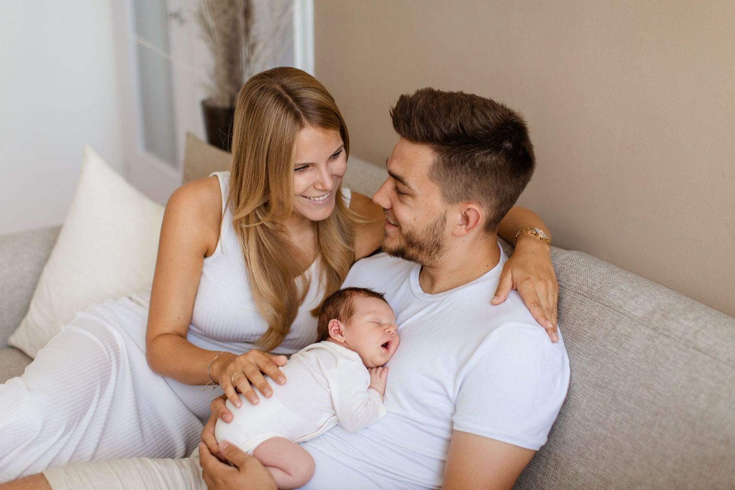 Eine vierköpfige Familie sitzt während eines Fotoshootings im Freien an einem freundlichen Tag auf einer Wiese zusammen.