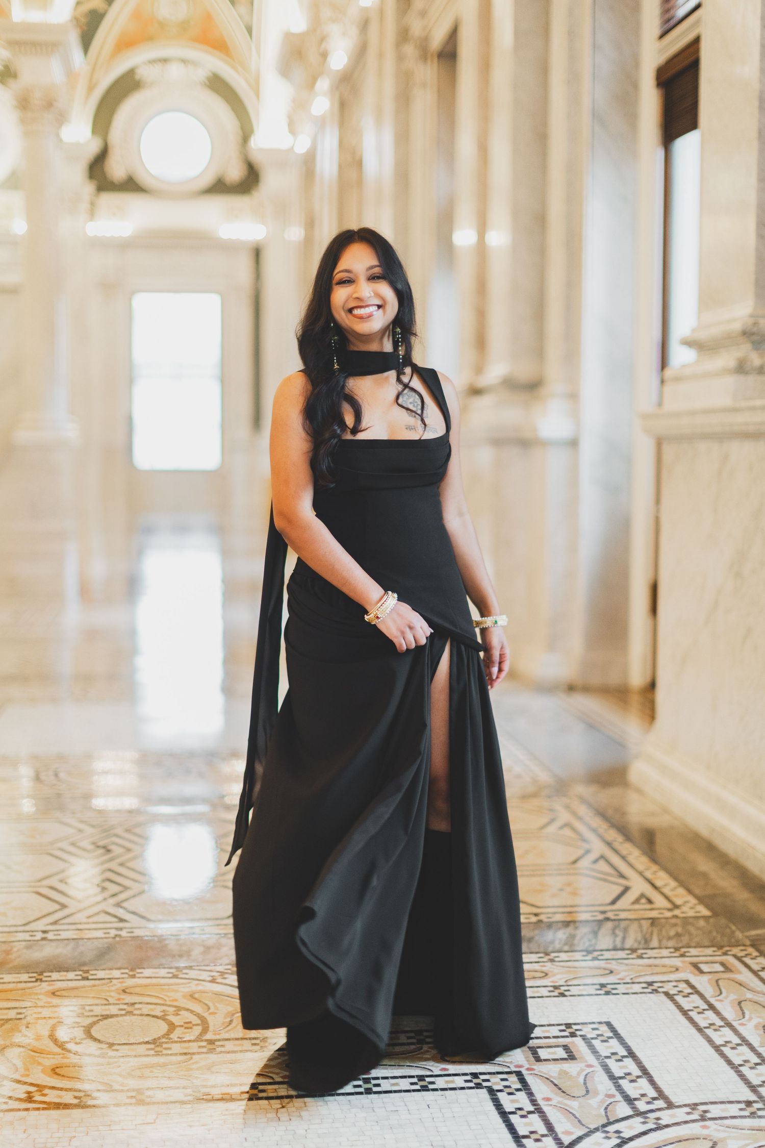 Woman in elegant black gown with slit posing in ornate marble hallway at the library of congress in washington dc