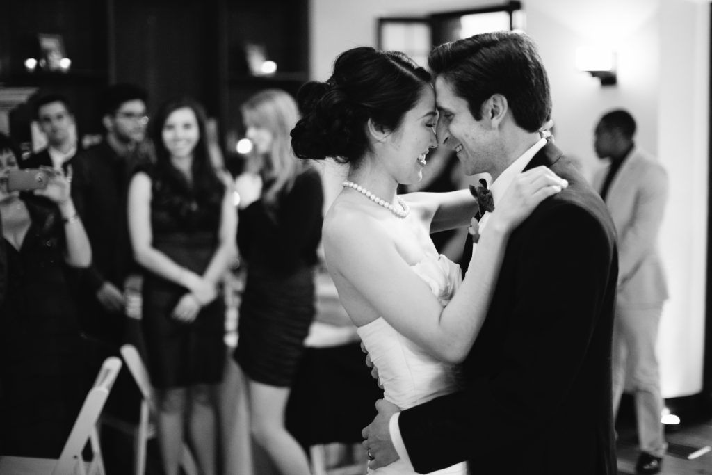Black and white photo of couple sharing intimate dance at wedding reception.