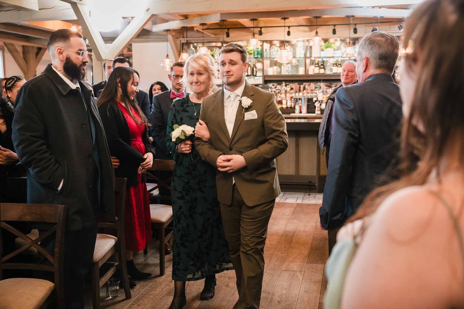 Groom walking down the aisle with mother during wedding ceremony processional at Briar Barn Inn