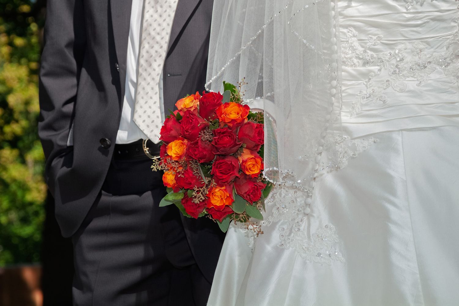 Brautpaar mit rotem Brautstrauß bei einer Hochzeit. Professionelle Hochzeitsfotografie und emotionale Reportage von der Lichtkapsel.