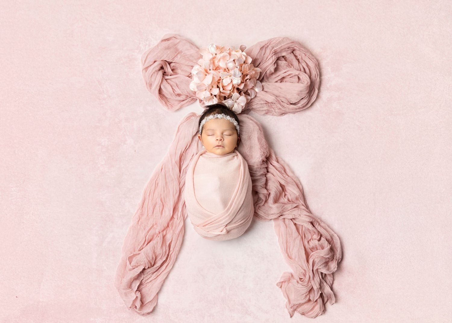 Newborn photography session in Covina CA, baby girl swaddled in pink with floral styling by Ester Nguyen Photography