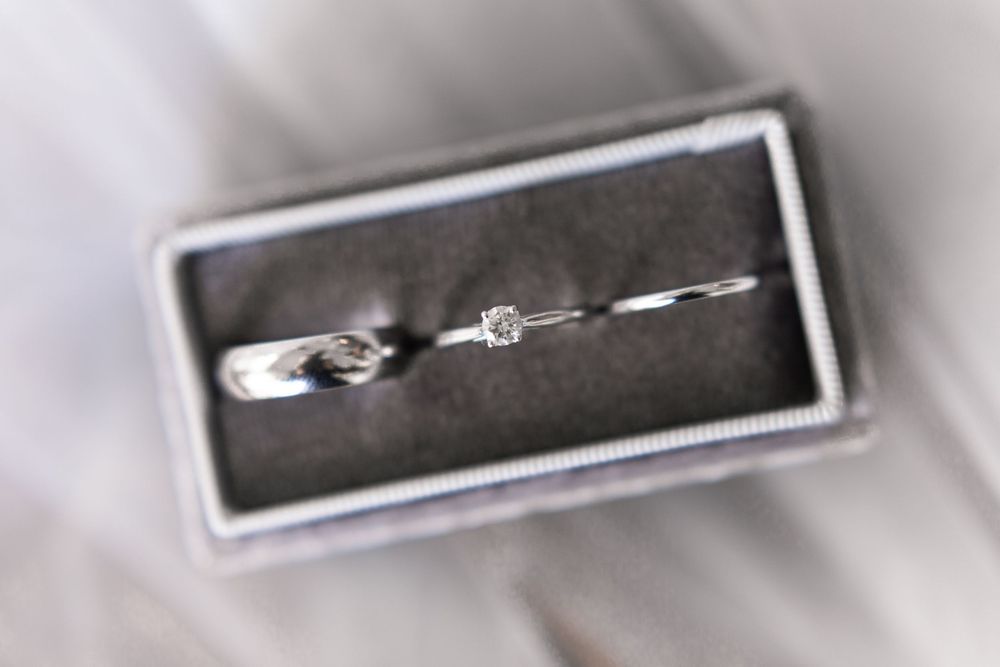 Diamond engagement ring and wedding band displayed in a gray velvet jewelry box.