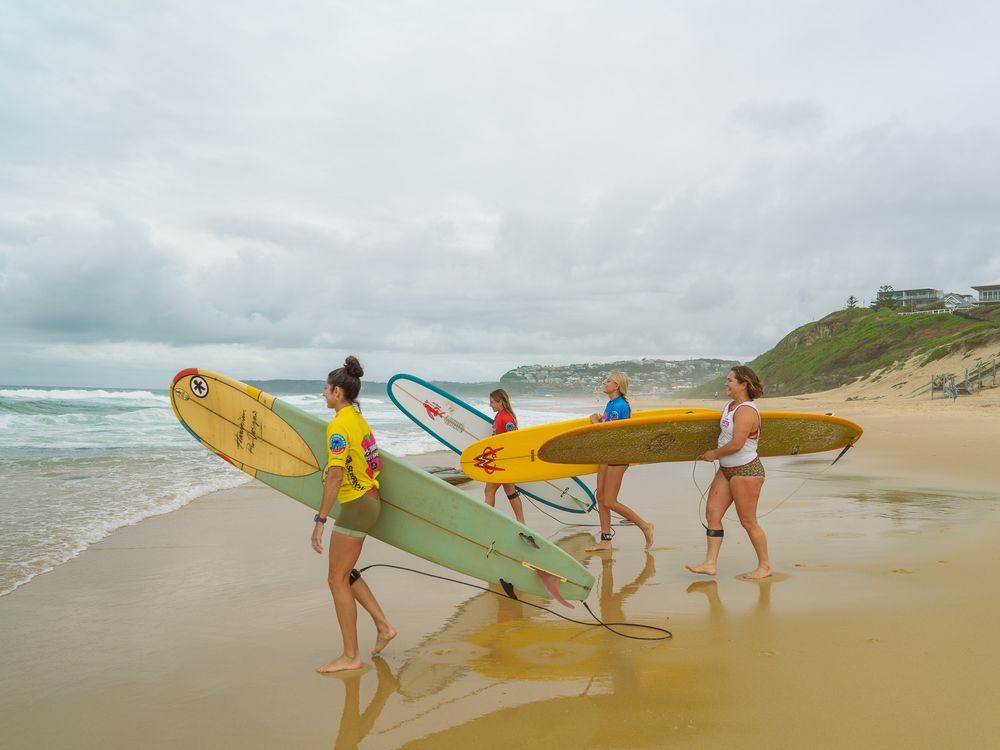 photo of 4 female surf competitors about to head out for their heat at Matara Classics held at Bar Beach NSW