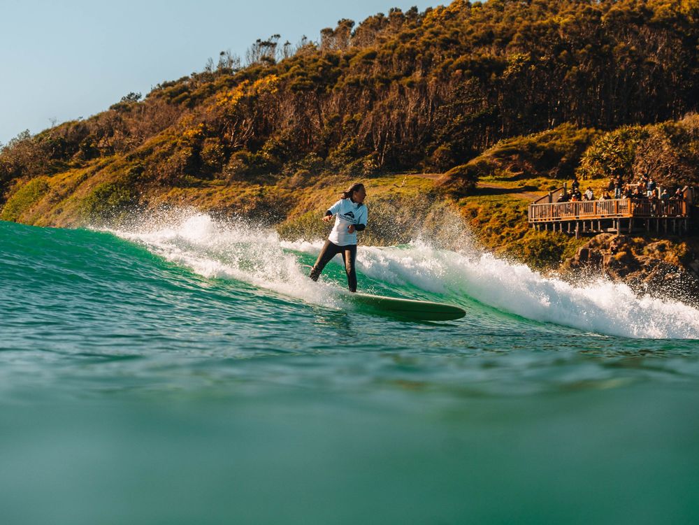 over 50s woman completing a turn during a longboard surfing competition at Scotts Head, NSW Loggerheads