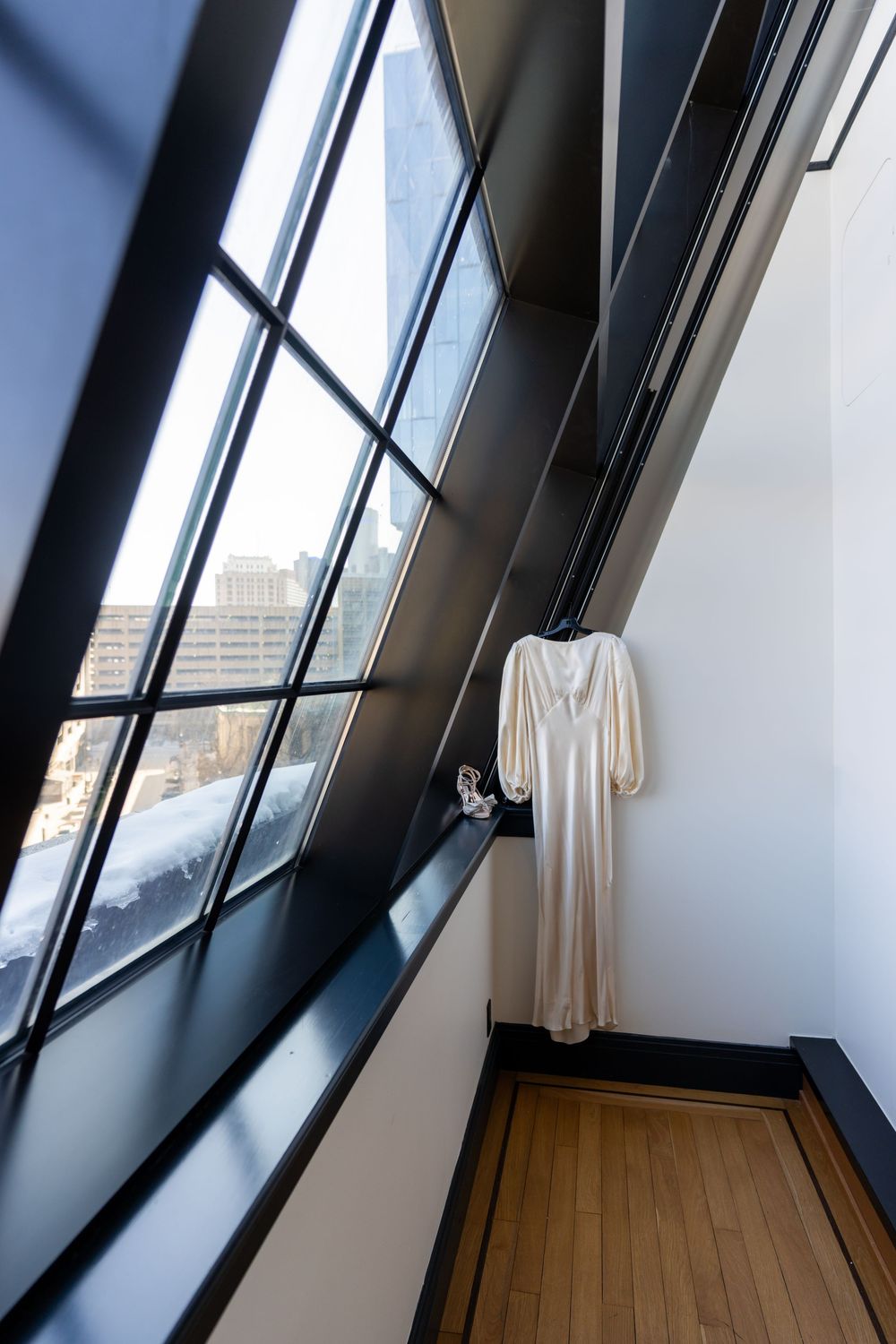 The iconic lines of a Shinola Hotel suite guiding your eye to a vintage inspired ivory, long sleeved wedding dress.
