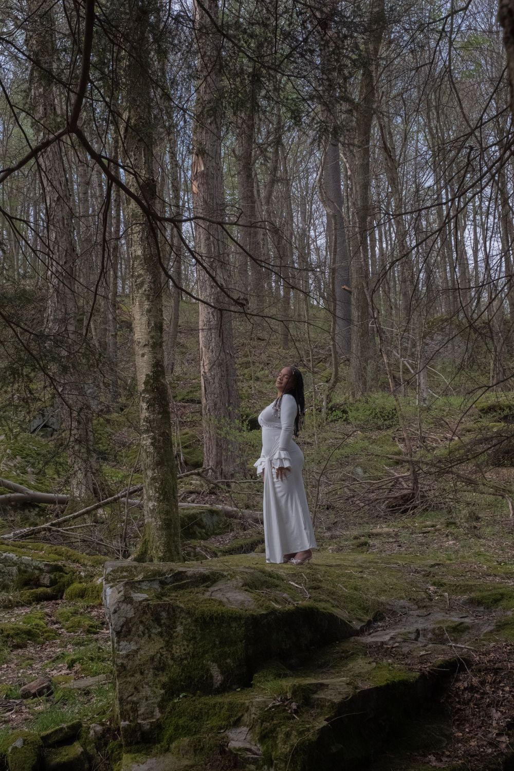 Woman in white dress standing on mossy rocks in a mysterious forest.

Uniontown, PA