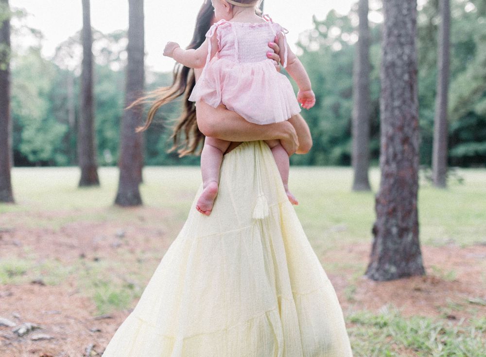 Whimsical photo of a Mother and baby walking through the woods at Sesquicentennial State Park during photoshoot