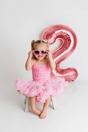 Winchester California 2nd birthday photographer: cute little girl in pink dress with pink 2 balloon.