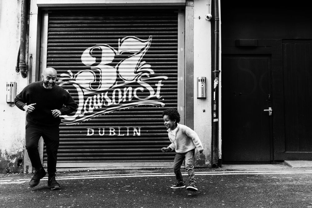 Black and white photo of adult and toddler outside 37 Dawson St Dublin storefront.