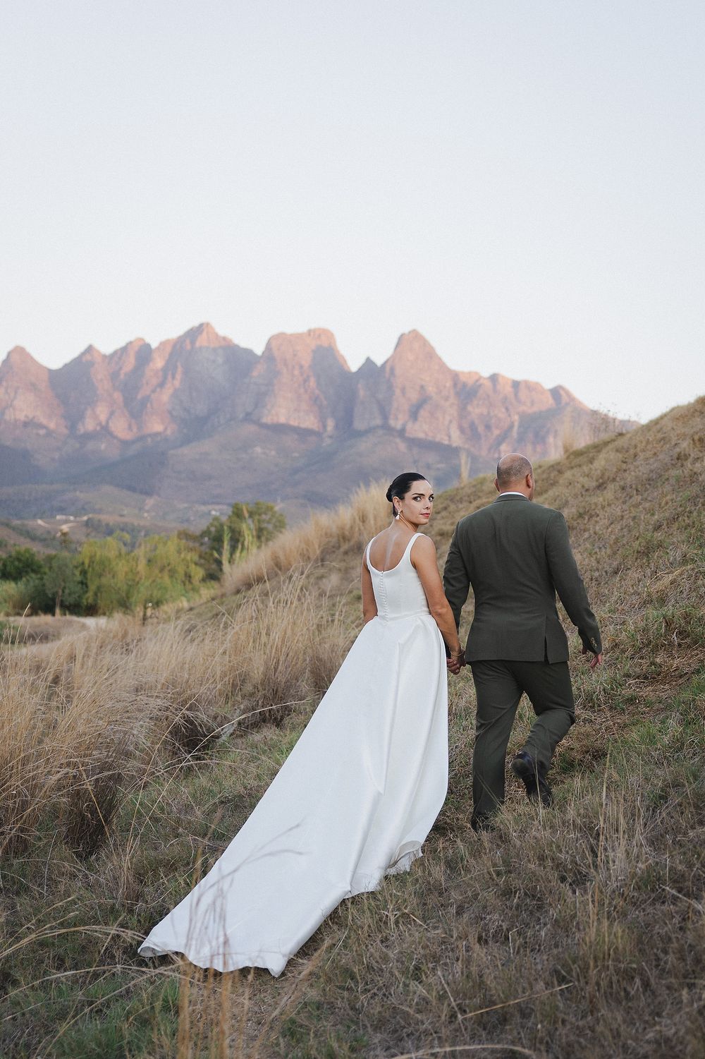 Bride and groom embracing at sunset in the Cape Winelands during romantic wedding portraits
