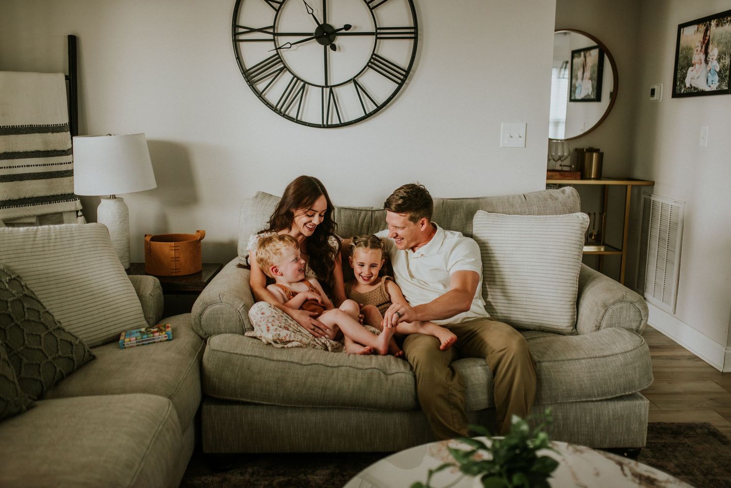 Family of four cuddling on the sofa during a lifestyle in home session with Karina Cantu Photography.