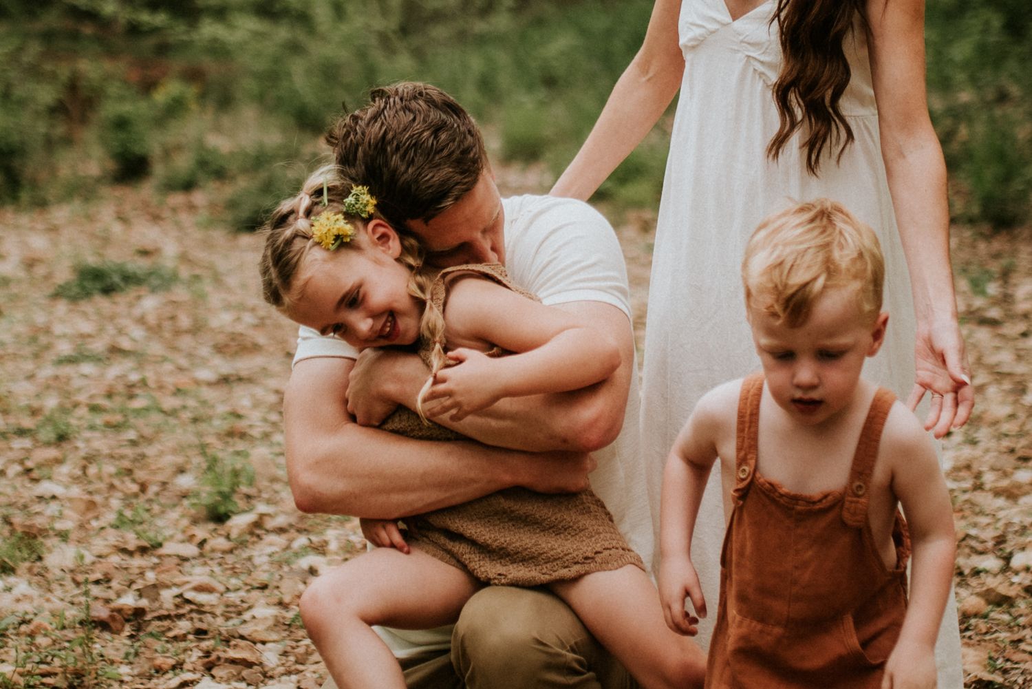 Dad squeezes his daughter full of love during a family session by the creek in Clarksville, TN.