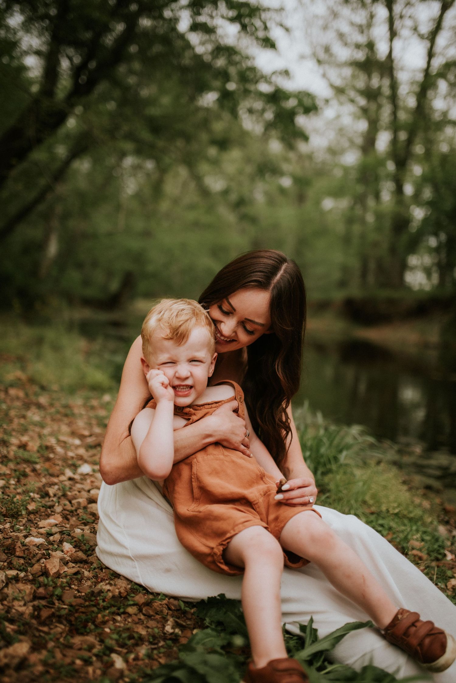 Mother holds son on her lap while he makes the scrunchiest cheese face at the family photographer in Clarksville, Tennessee.