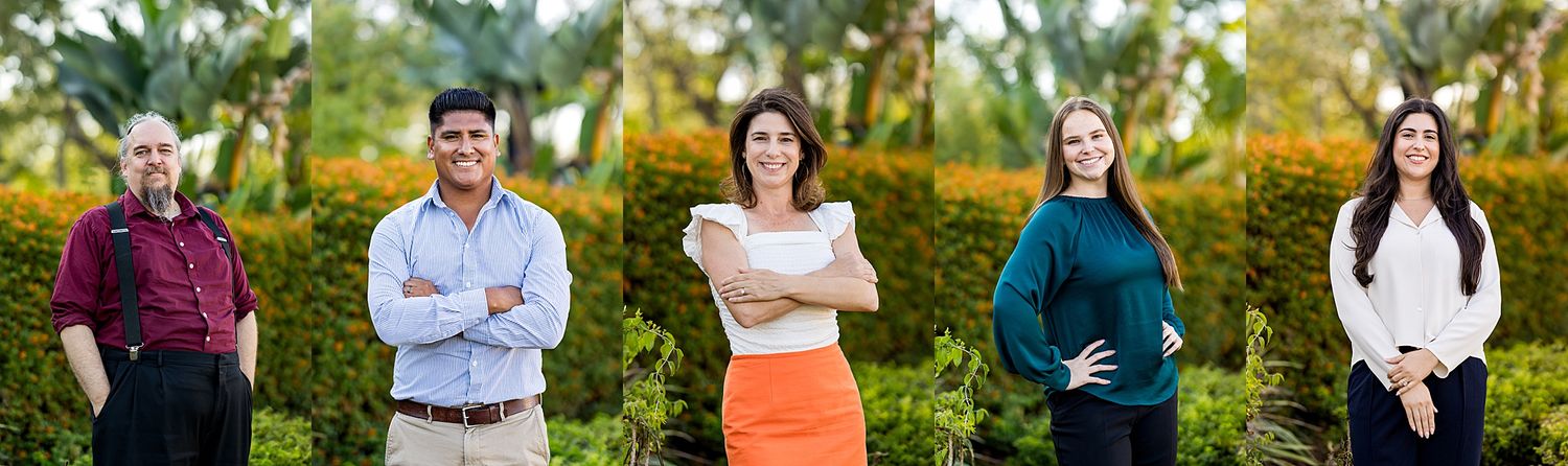 Four professional individuals posing outdoors in business attire among lush green foliage in a corporate team photo.