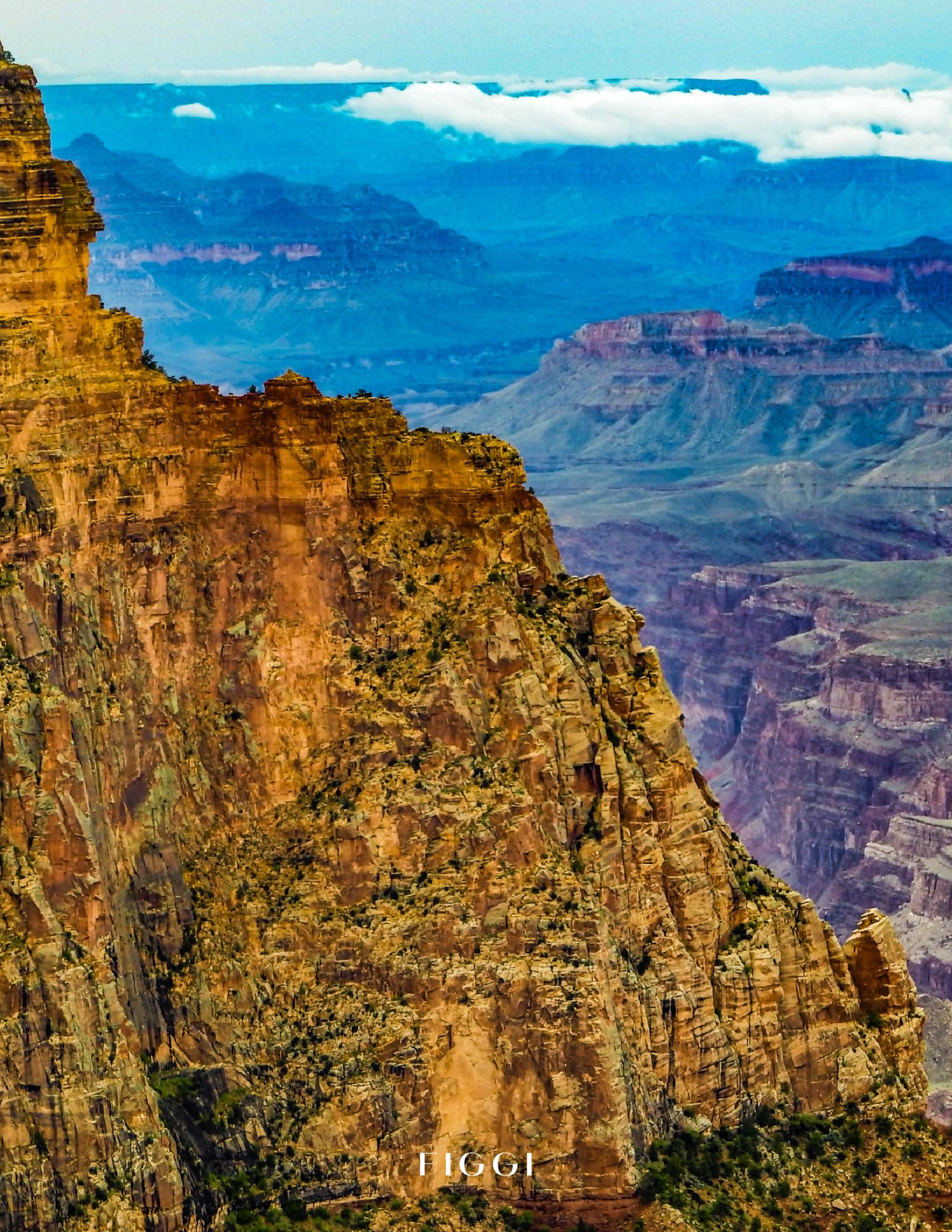 Stunning aerial view of the Grand Canyon's layered red rock formations with misty blue mountains in the background.