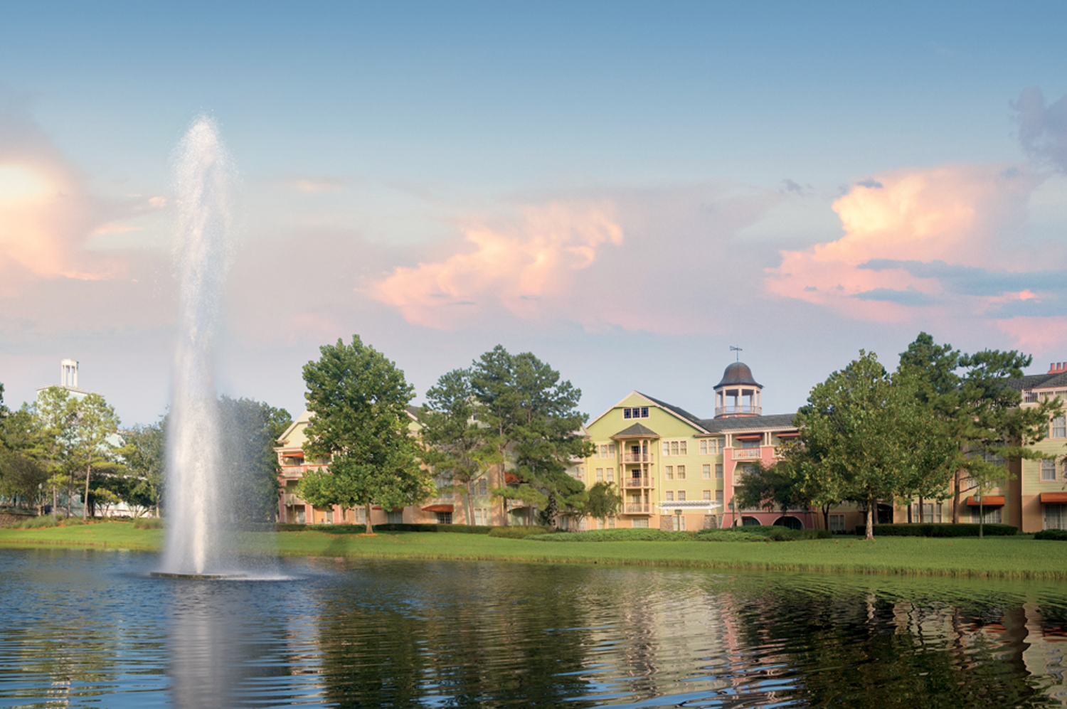 Lake view with fountain and resort buildings during sunset at Saratoga Springs.