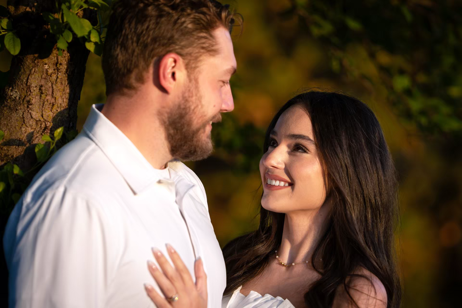 A smiling engaged couple sharing a romantic moment outdoors Franklin Park
