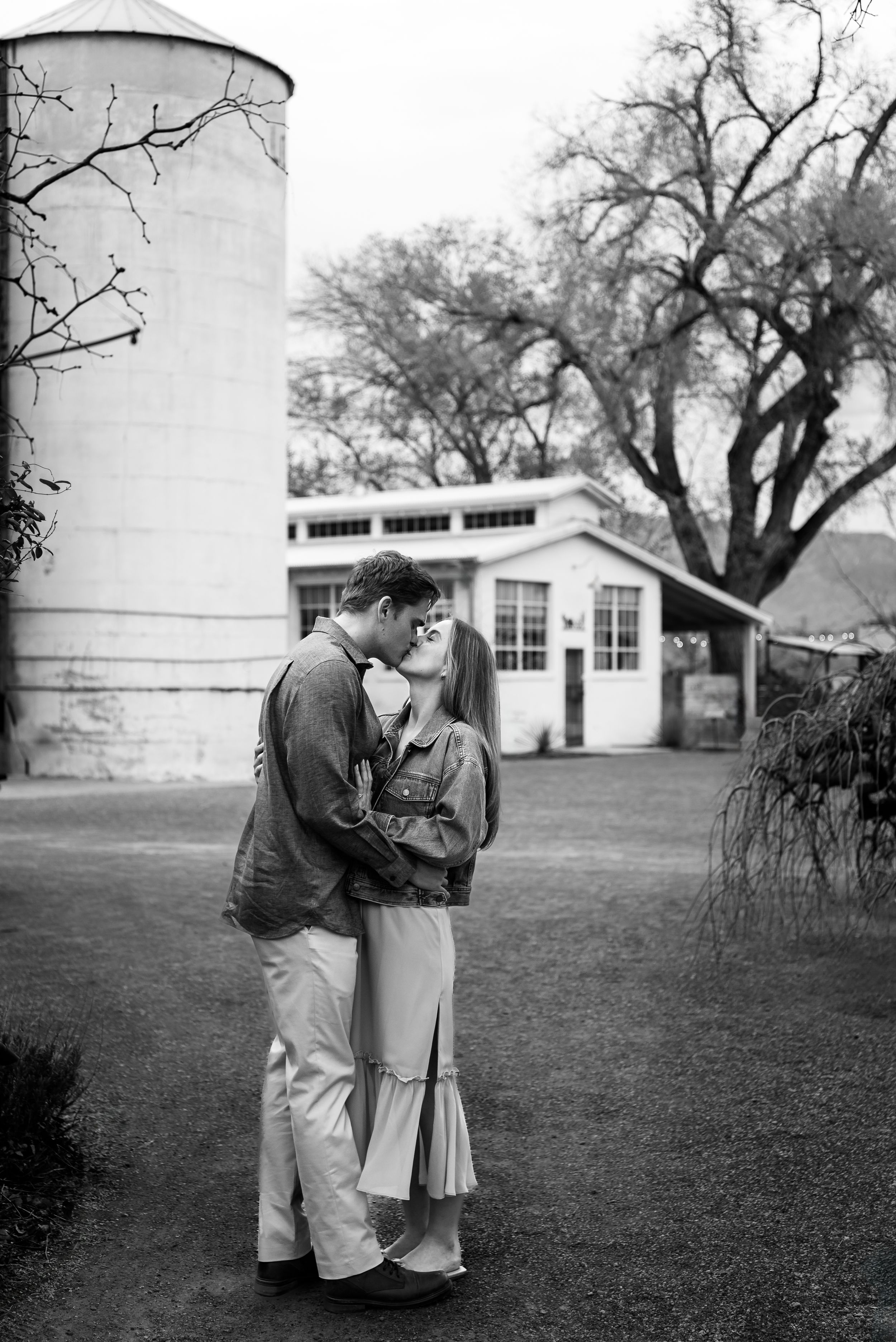 A tender embrace in black and white against a vintage architectural backdrop.