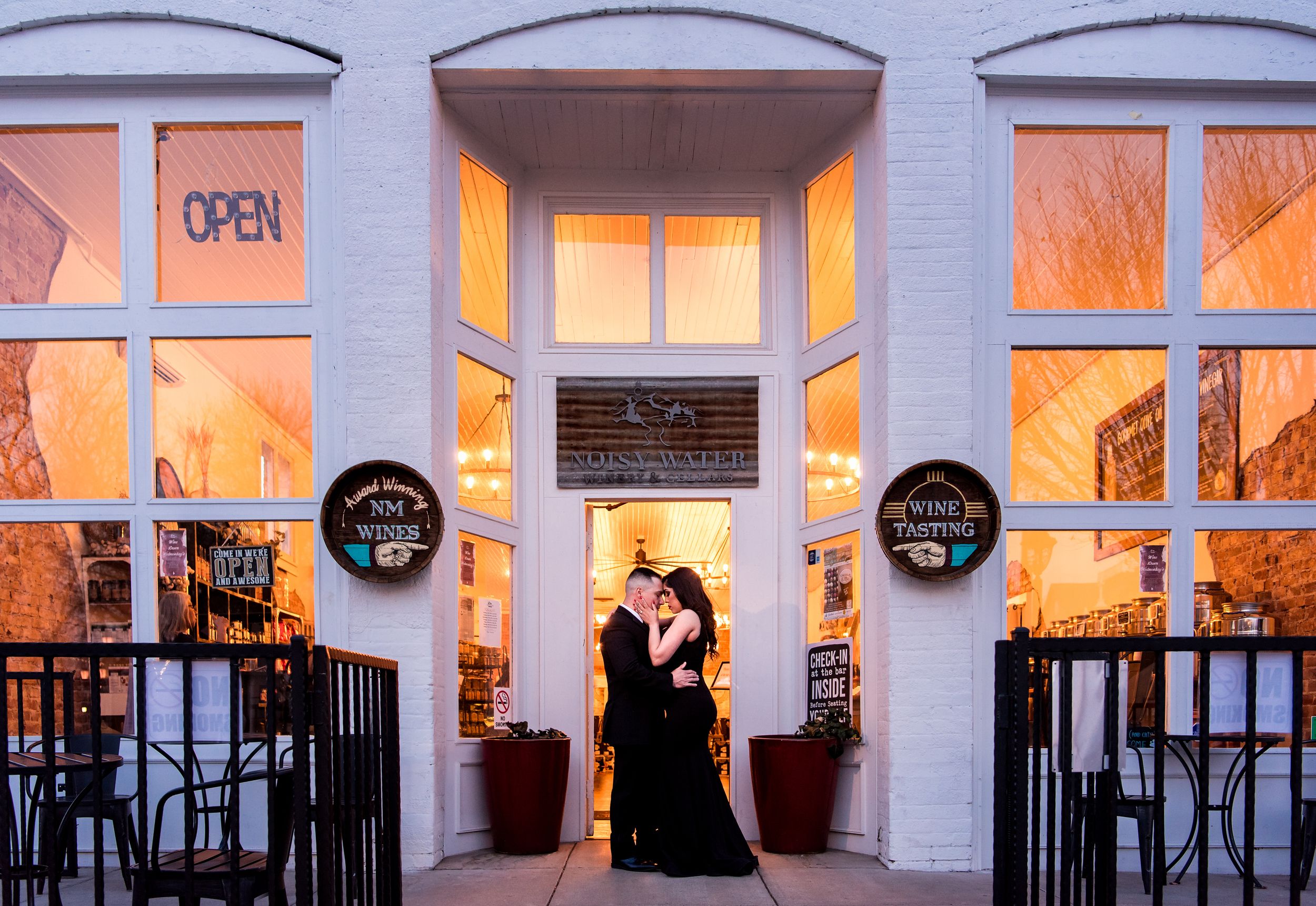 A romantic evening scene outside a lit storefront with decorative windows and an OPEN sign.