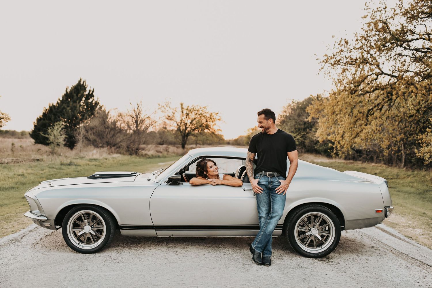 stylish engagement photos with black fastback Mustang and golden light