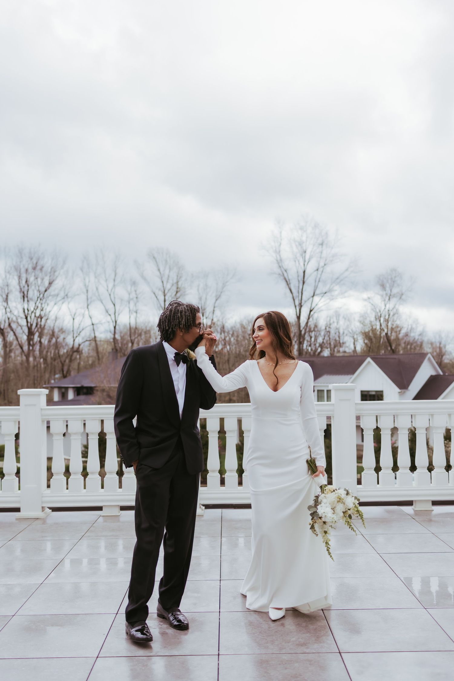 Groom kissing his bride's hand on their wedding day in Zionsville, Indiana at Holliday Farms