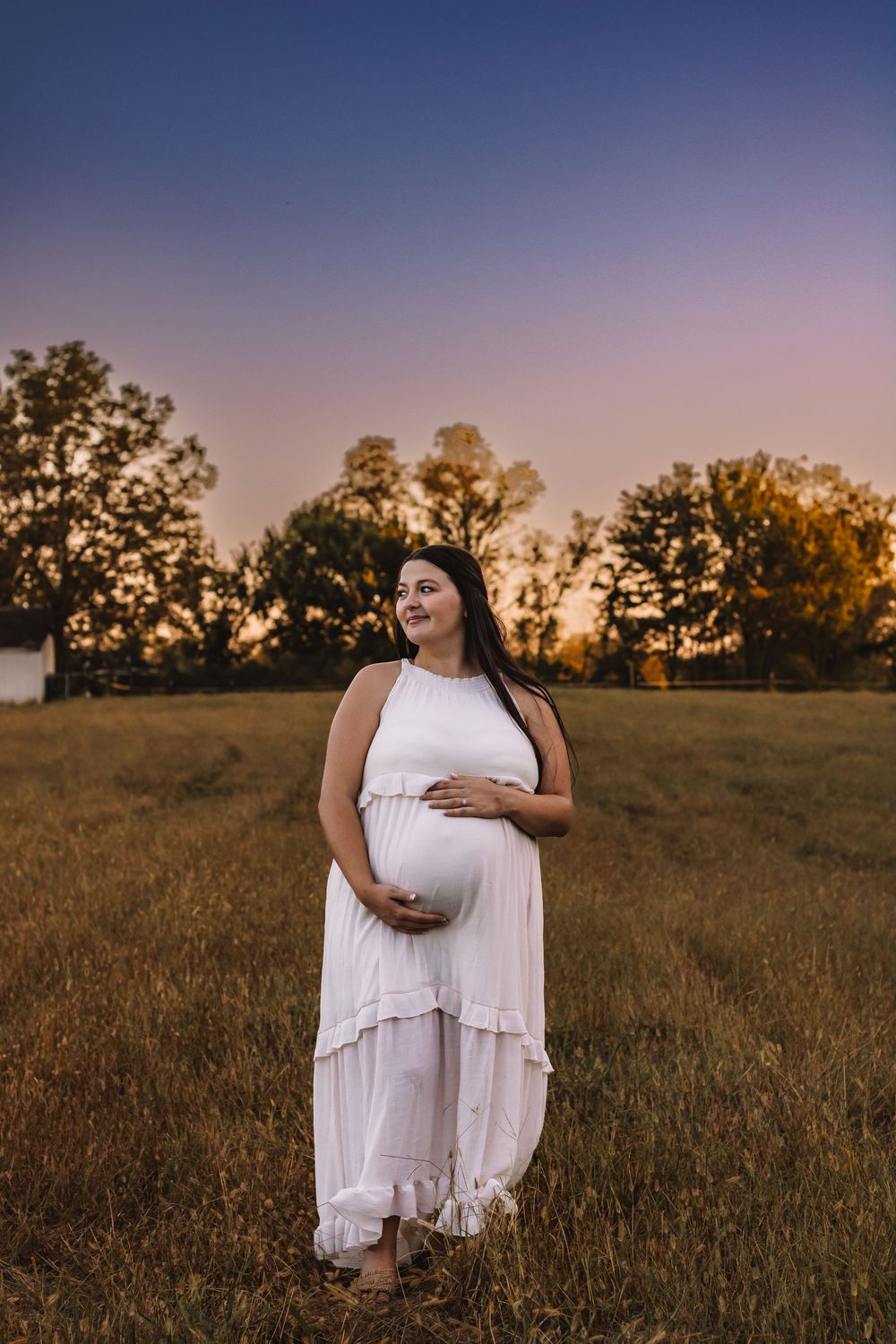 Expecting mother holding her growing belly in natural outdoor scenery in lewis county Washington