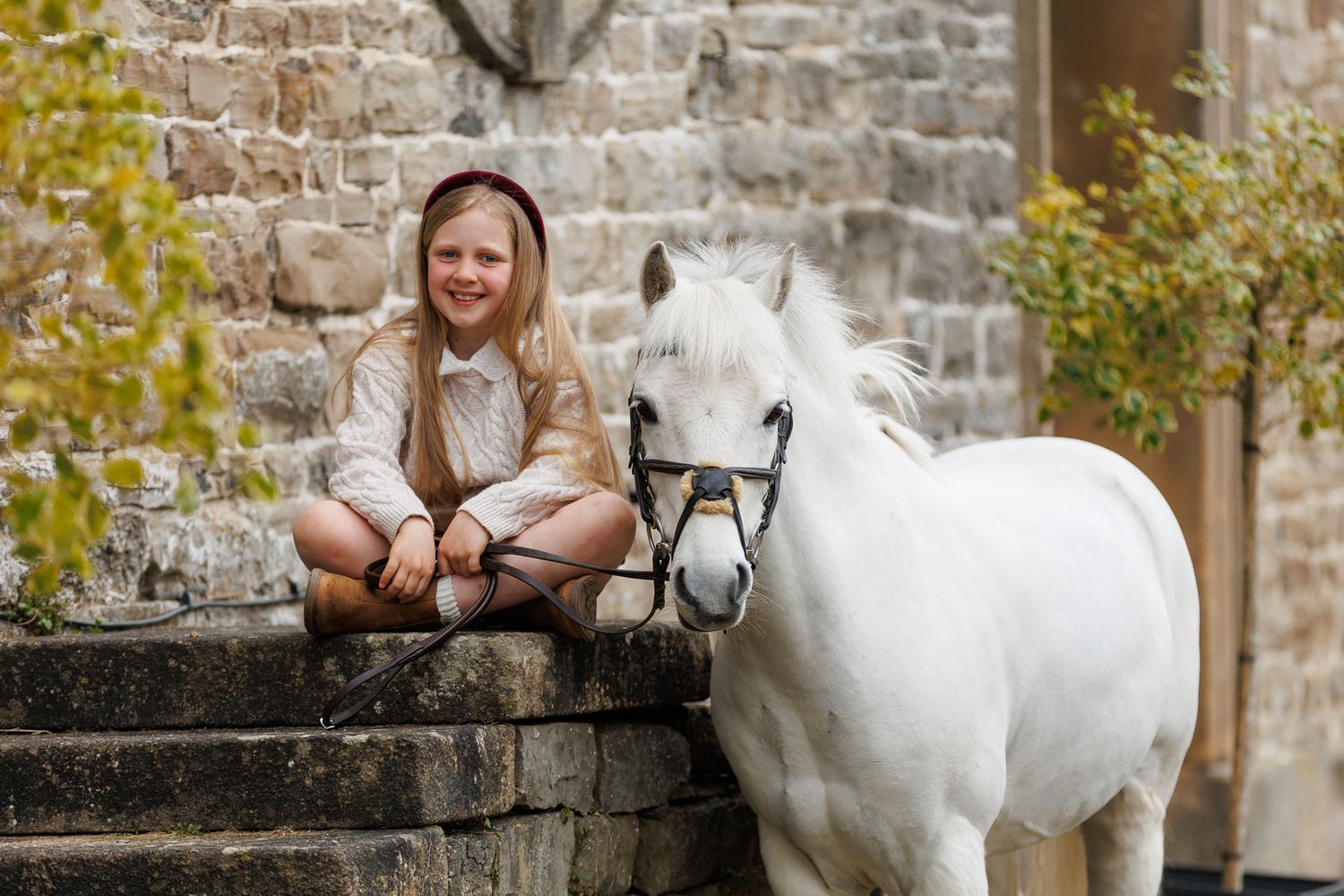 A beautiful black and white paint horse stands with a person on a sunny autumn day outdoors.