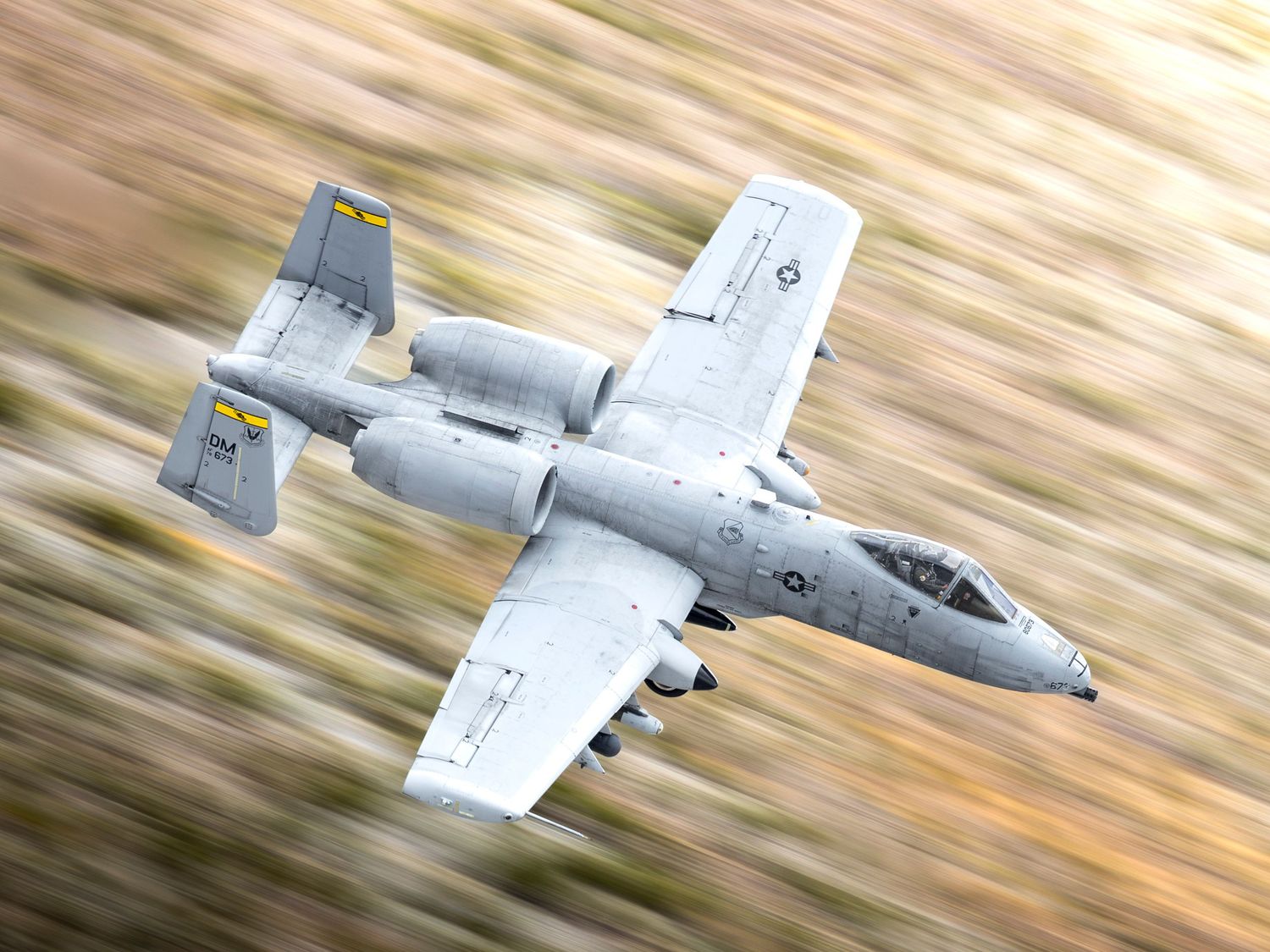 an A-10C flying a great speed along the desert floor