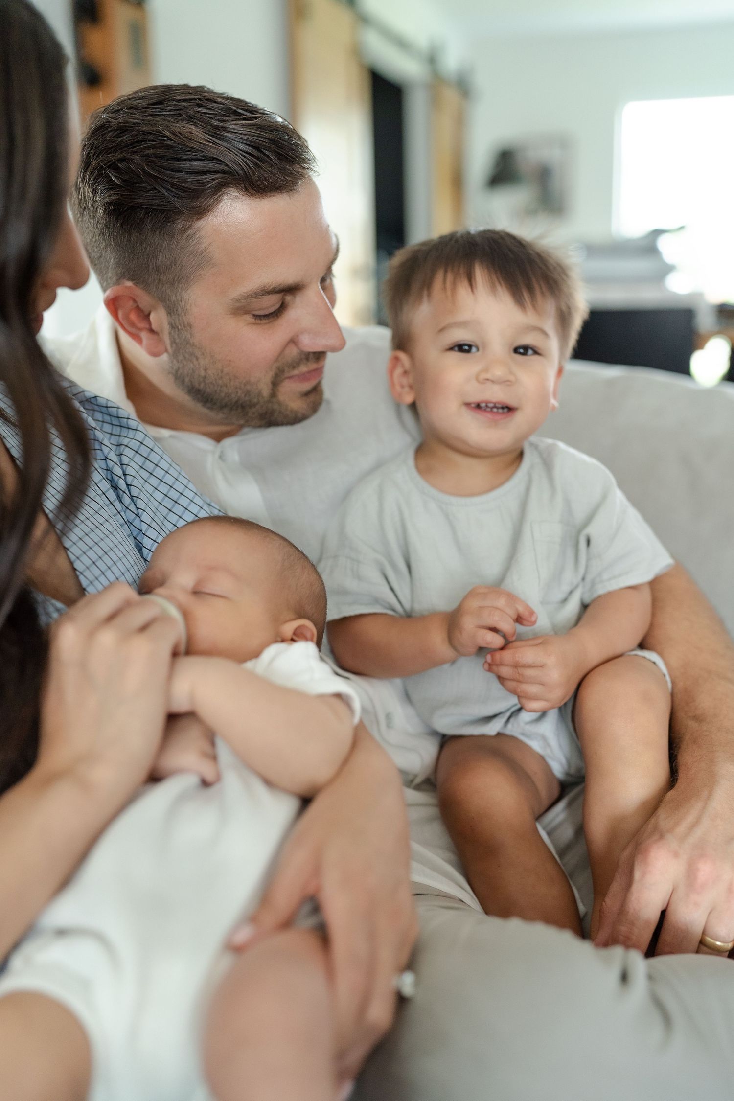 newborn family photo in living room family wearing neutral tones