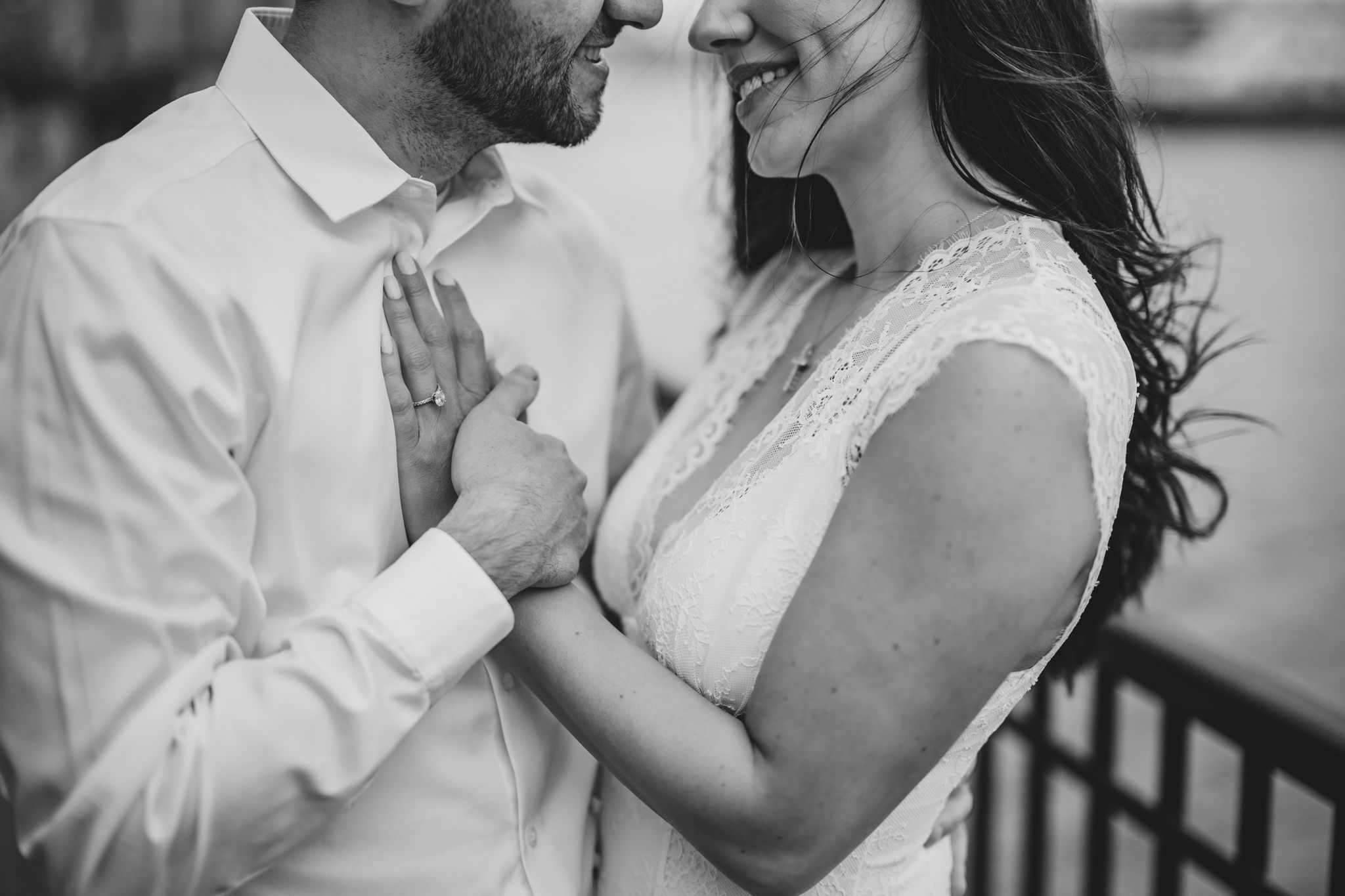 Black and white photo of a smiling bride and groom sharing an intimate moment on their wedding day.