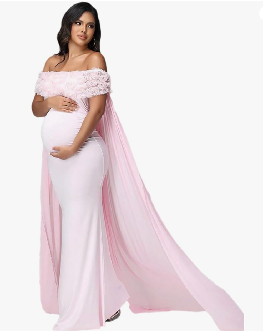 Pregnant woman wearing a pink off-shoulder lace maternity gown with flowing chiffon cape overlay.