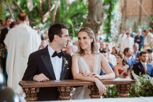 An elegant wedding reception setup with floral decorations and guests seated at long tables.