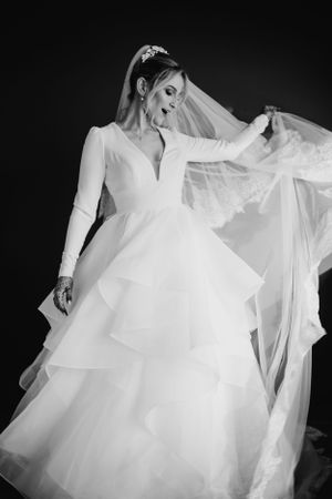 Close-up details of a flowing white wedding dress with delicate layers of tulle and fabric.