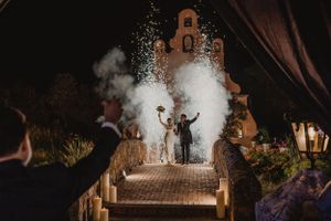 Wedding celebration with sparklers and smoke creating magical atmosphere at night.