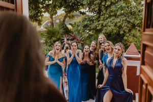 Wedding party in coordinated blue dresses walking together.