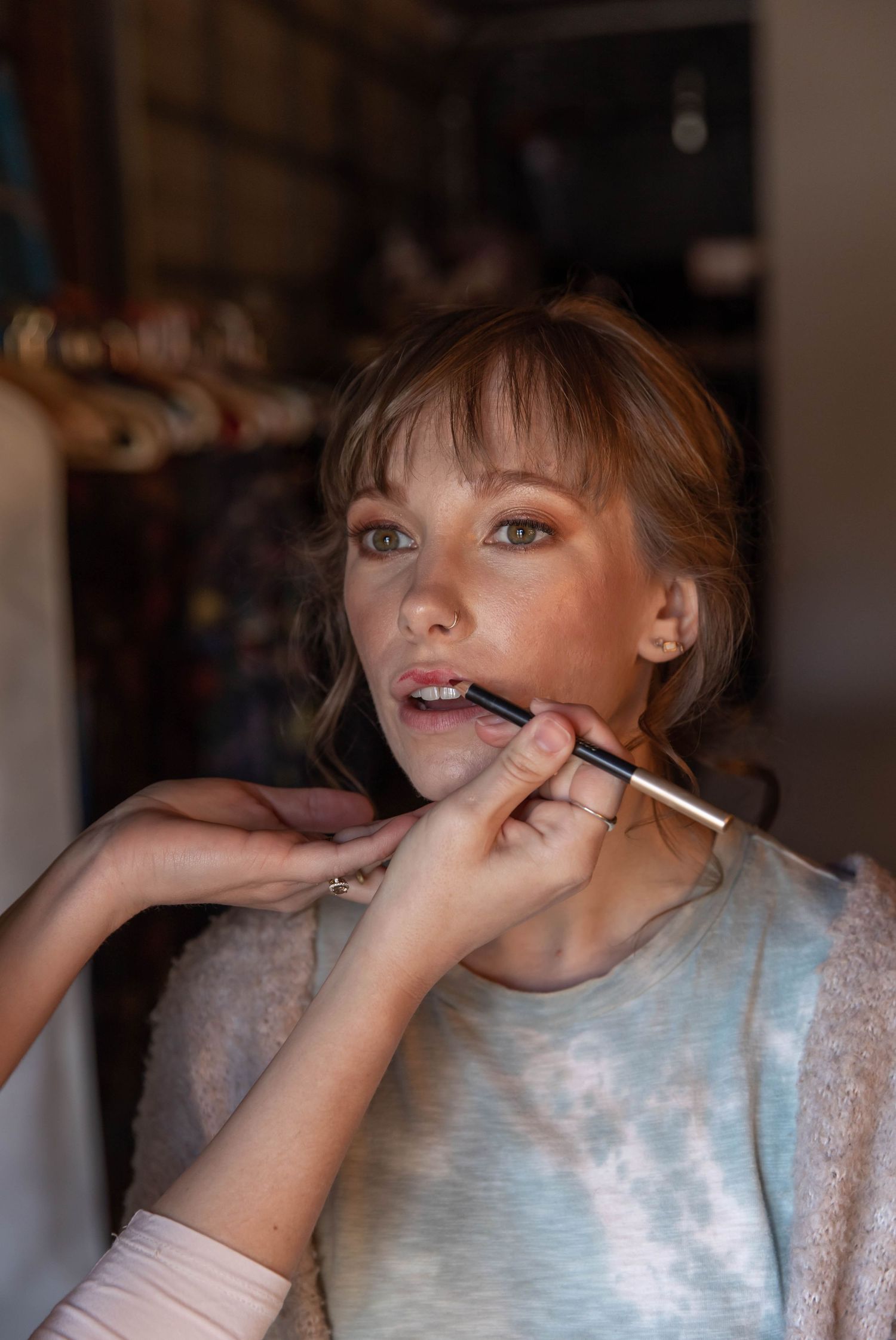 Photo of a bride getting her makeup done before her wedding