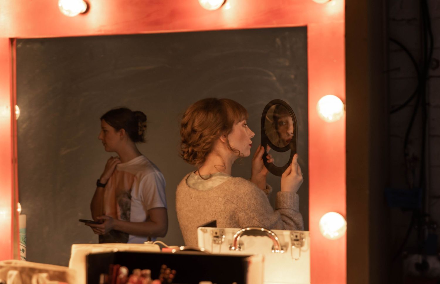 Photo of a bride looking at her hair in the mirror before walking down the aisle