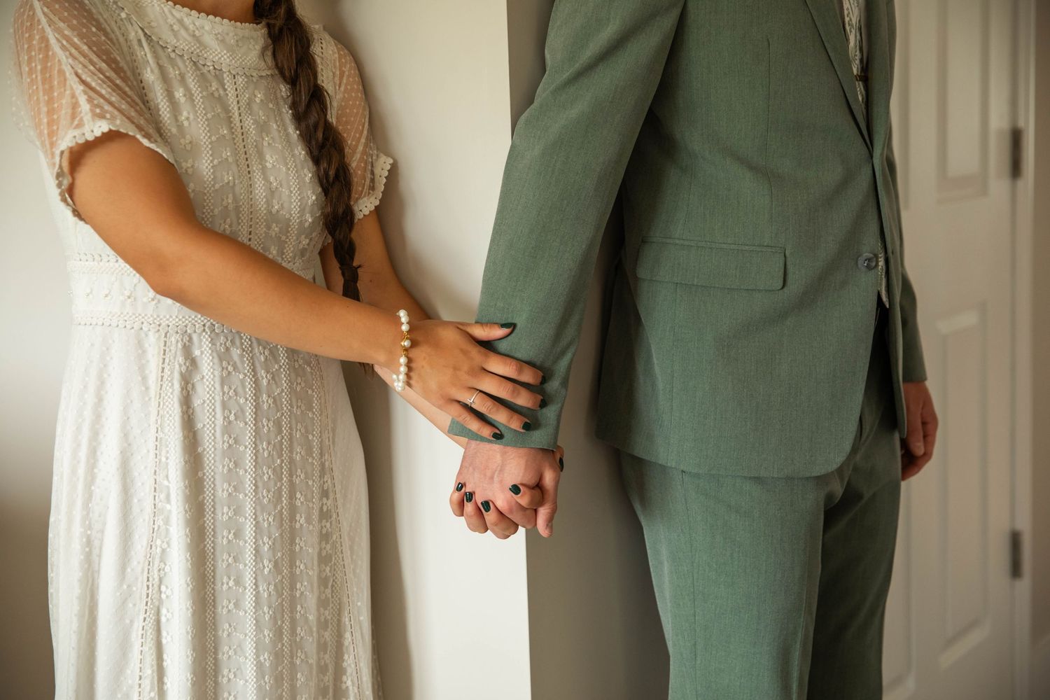 Photo of a bride and groom holding hands around a corner while they pray together before their wedding ceremony. Abingdon, Virginia wedding