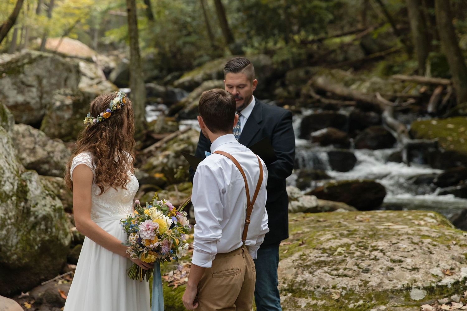 Photo of a bride and groom saying their vows along the creek in Cascades National Recreation Area