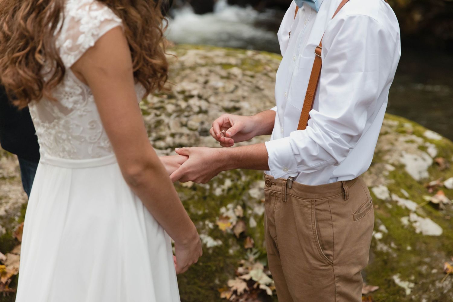 Photo of a bride and groom as he is about to place the ring on her finger