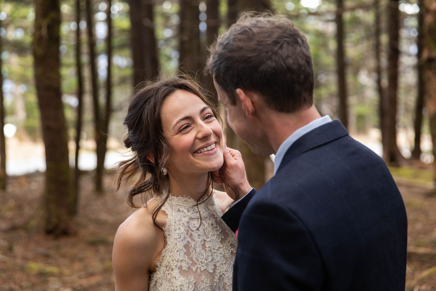 Photo of a bride and groom standing in the woods, looking lovingly at each other, with his hand on her face. Whitetop Mountain, Virginia