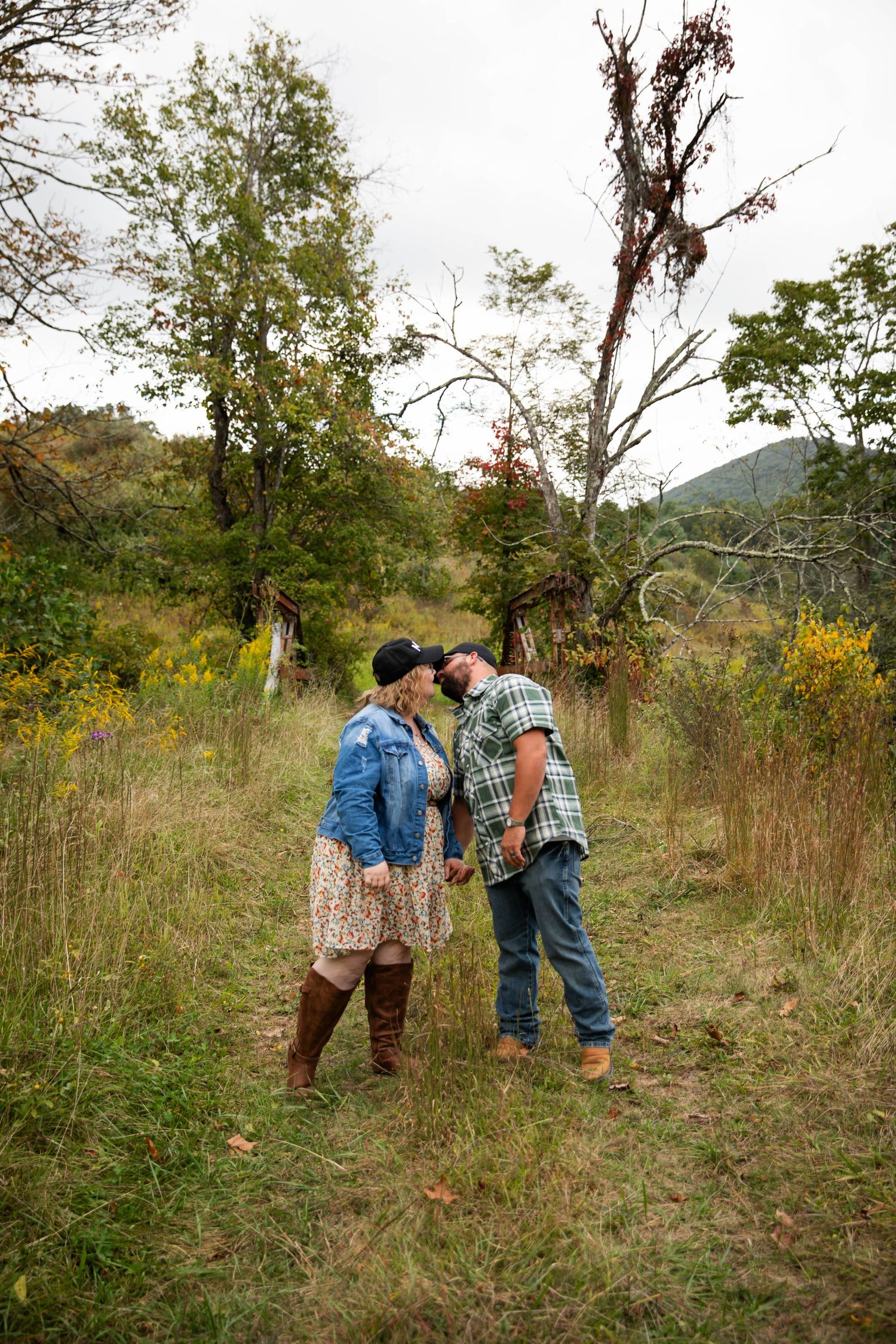 Photo of a couple kissing in a field of yellow flowers. Couples shoot in a field of yellow flowers.